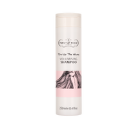 A 250 ml bottle of Percy Reed Volumising Shampoo, featuring a cream-colored cap and body with a pink band and an illustration of long dark hair on the label.


